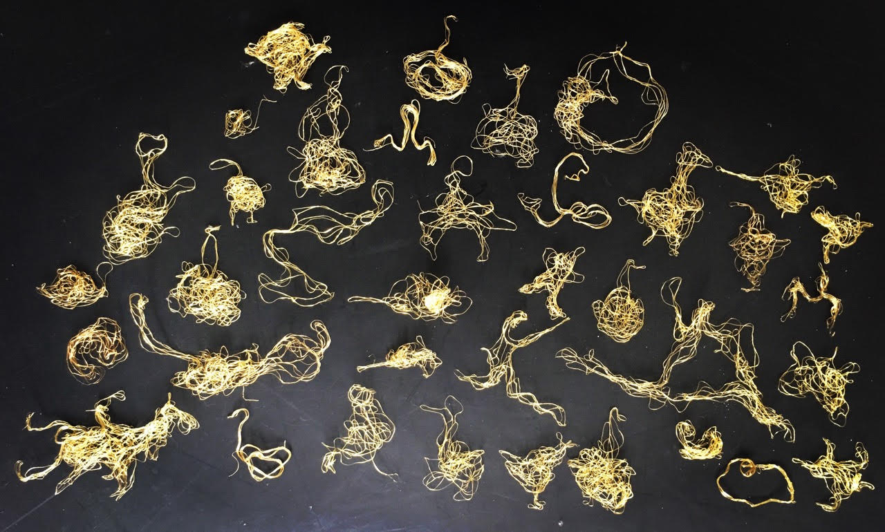 Set of abstract brass-coloured wire animals.