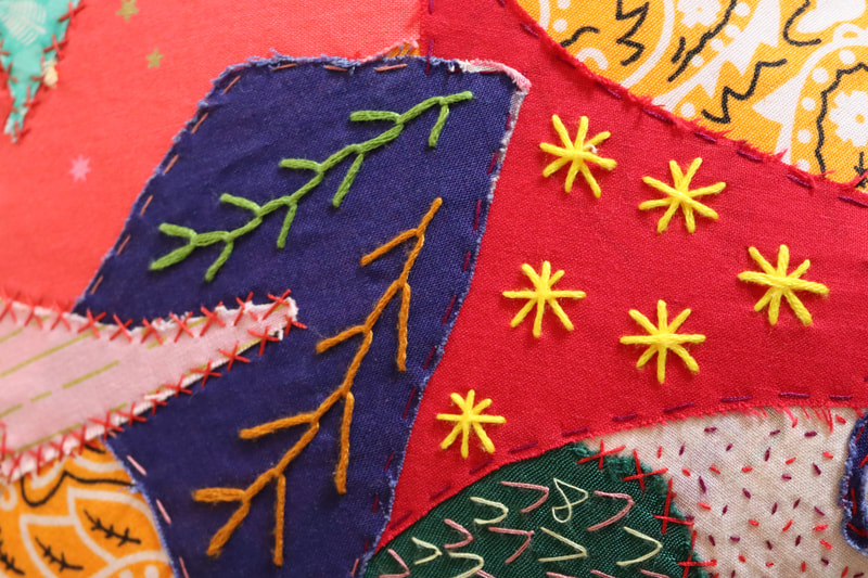 Detail of applique embroidery in red, yellow  and navy. 