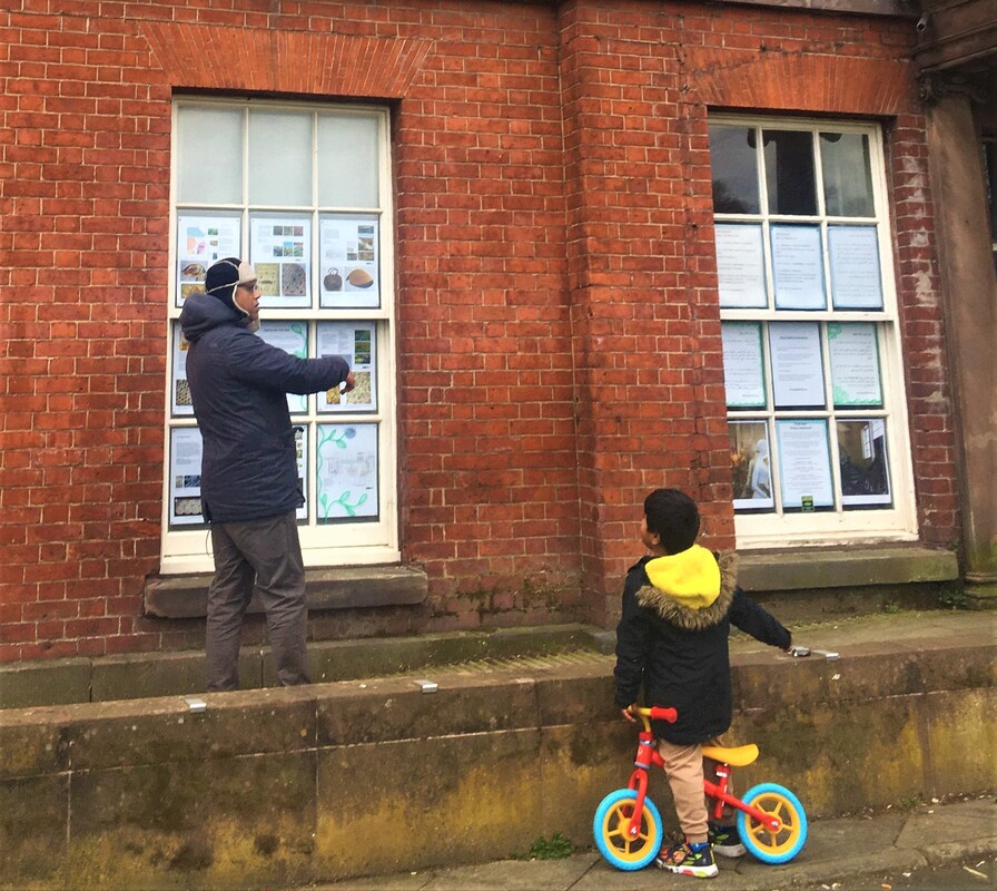 Man and child looking at window displays outside the Hall