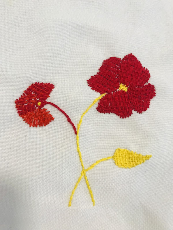 red stitched flowers with yellow stem and leaf