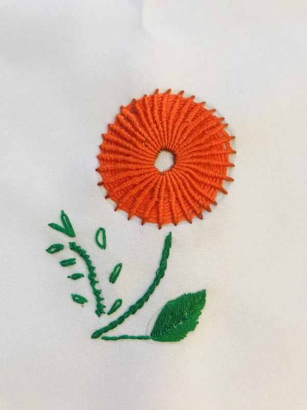 Orange embroidered flower with green stitched stem