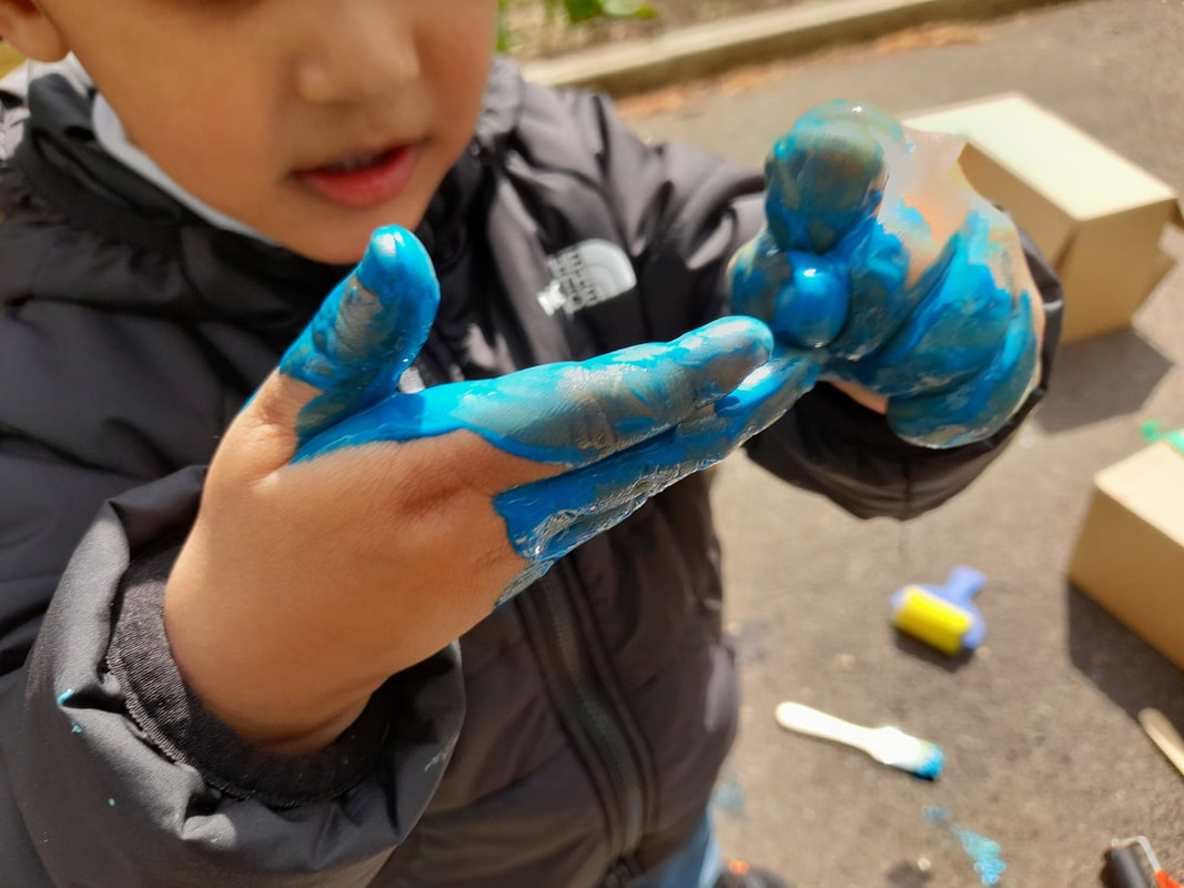 Close up of small child with blue painted hands.