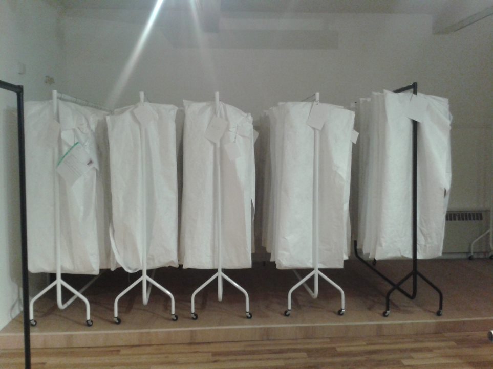 Rails of garments in Tyvek covers
