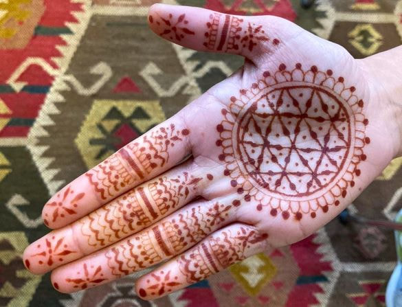 Henna designs painted on an upturned hand.