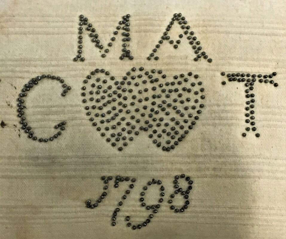 Detail of pincushion, cotton with inscription in pins, 'MA, CT, 1798'.