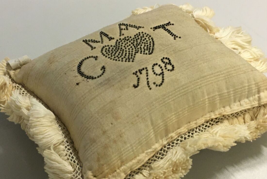 Pincushion, cotton with inscription in pins, 'Welcome little Stranger, MA, CT, 1798'.