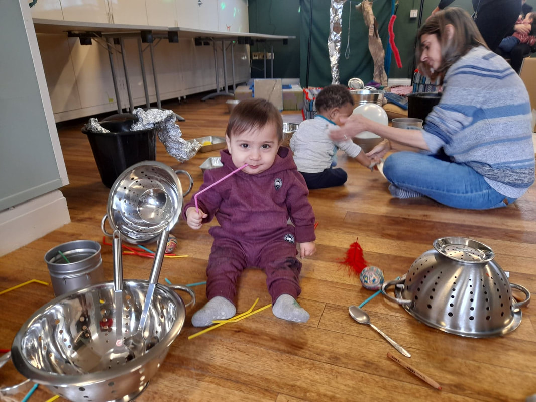 Small child playing with pots and pans in a play session.