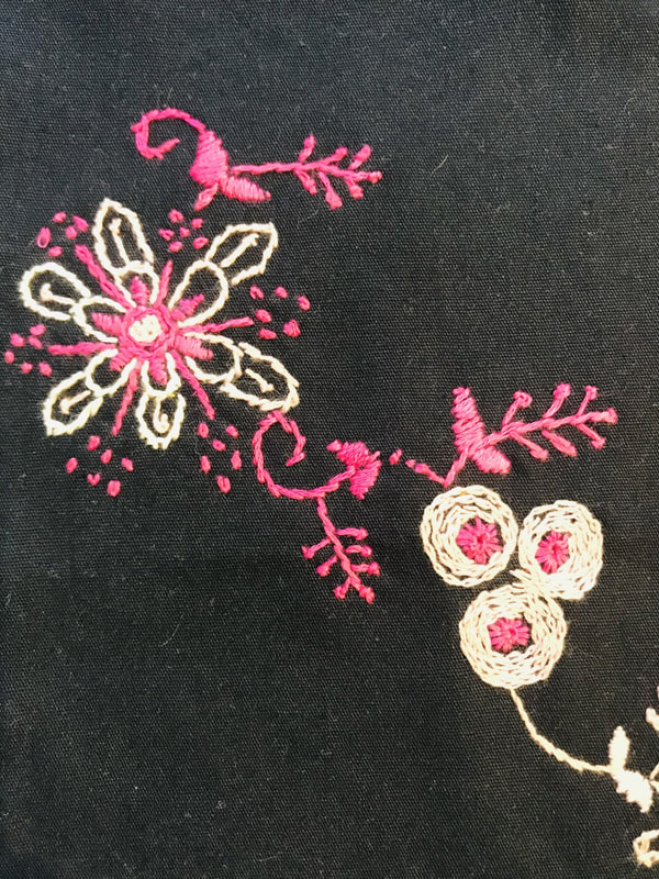 Pink and white embroidery on navy fabric